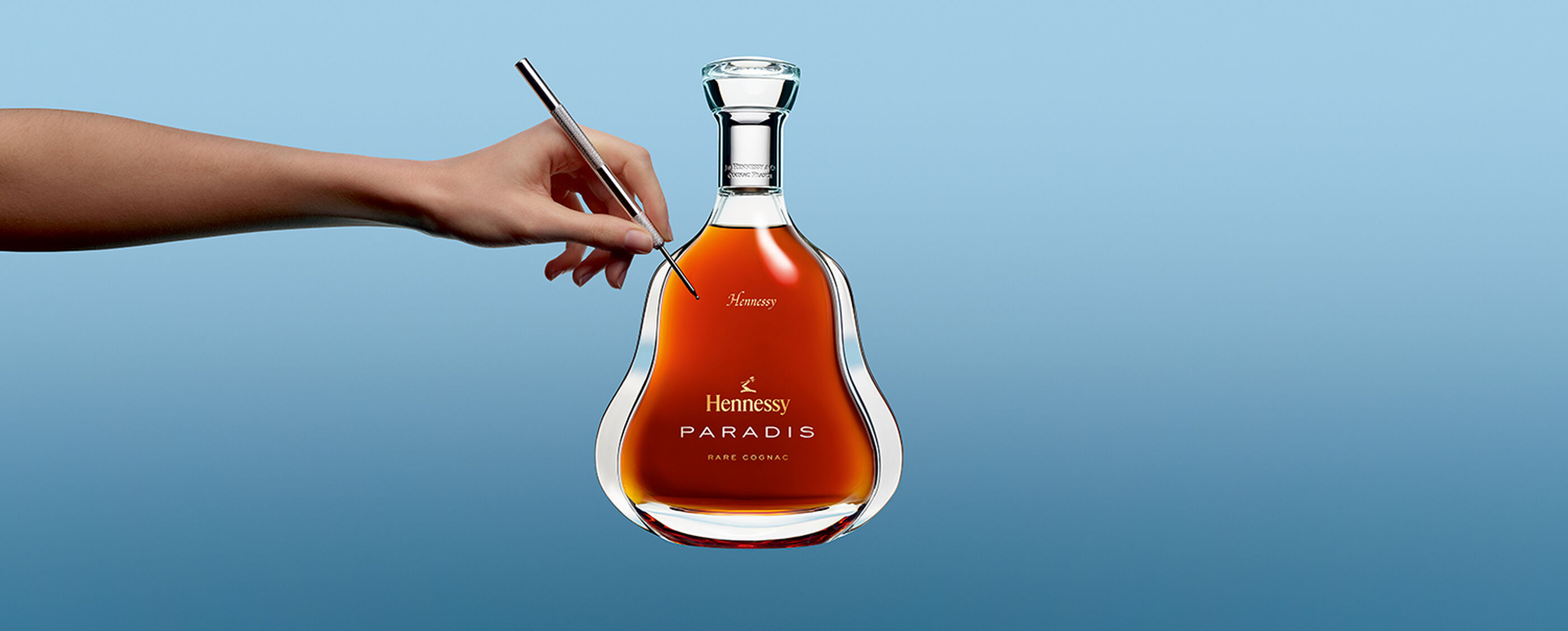 A hand holds a Hennessy Hands bottle.